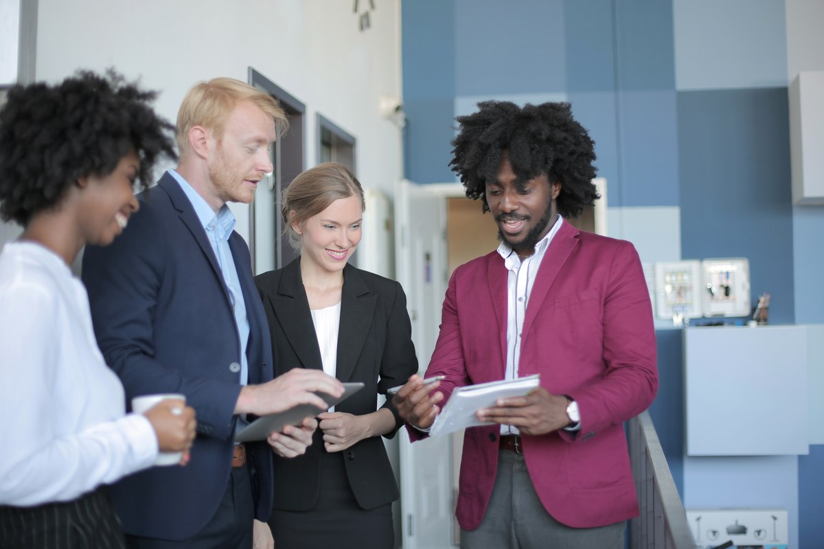 Een divers team van collega's overlegt samen op kantoor
